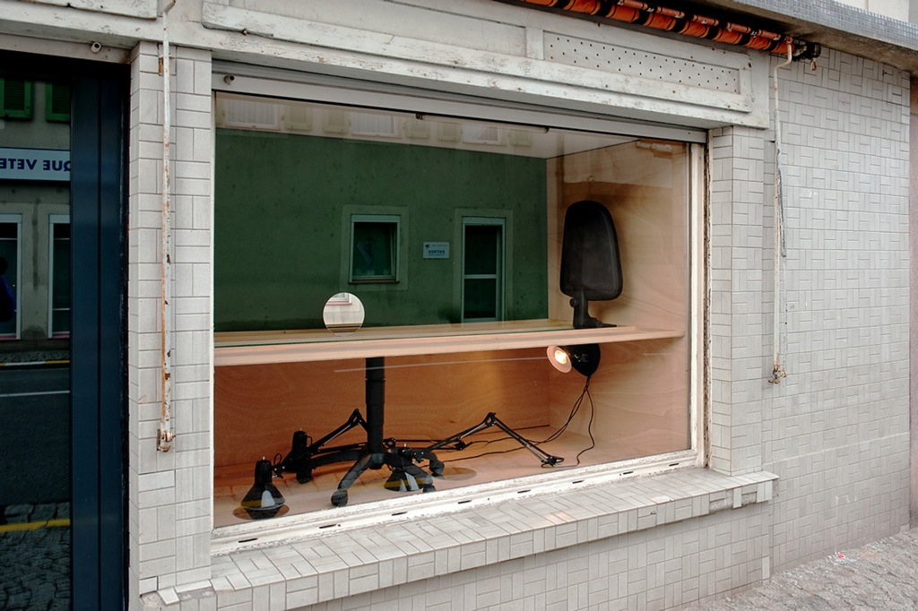 L'organisation du travail, 2011 - Schaufenster - 19ème Biennale d’art contemporain de Sélestat - bois , chaise de bureau farine, lampe, miroir.